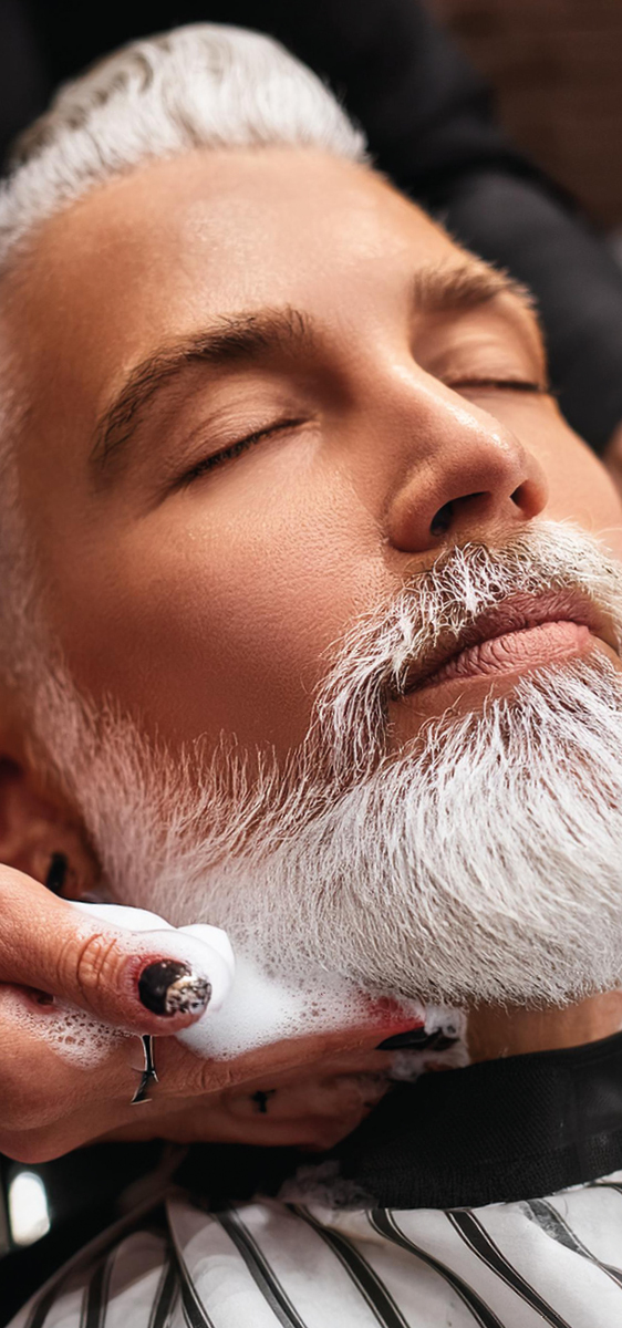 Uomo con barba lunga e bianca, coperta di schiuma